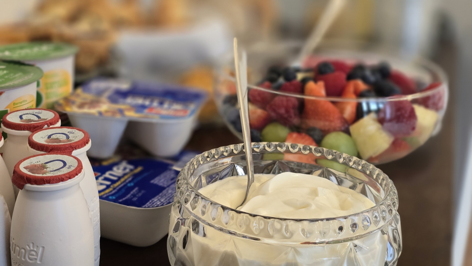 Fresh fruit salad and yoghurt in cut-glass bowls at breakfast
