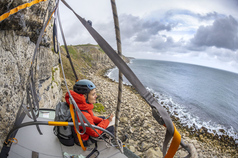 A climber on the limestone sea cliffs of Portland