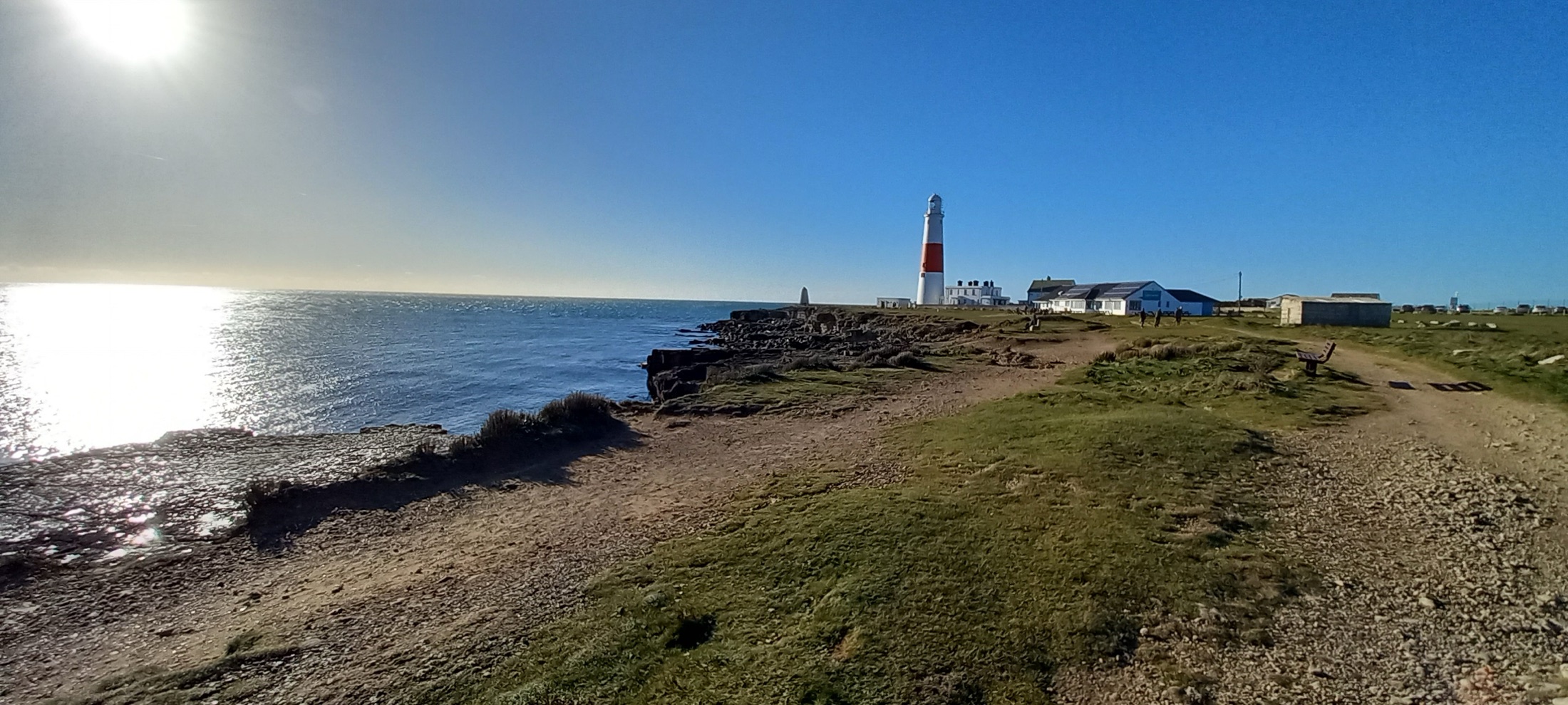 Portland Bill lighthouse under a bright winter sky with the sea glittering