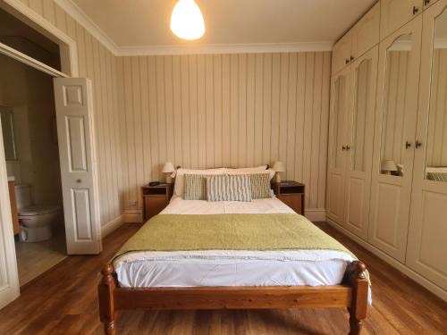 Double room with a pine bed, green throw and en-suite bathroom through the open door